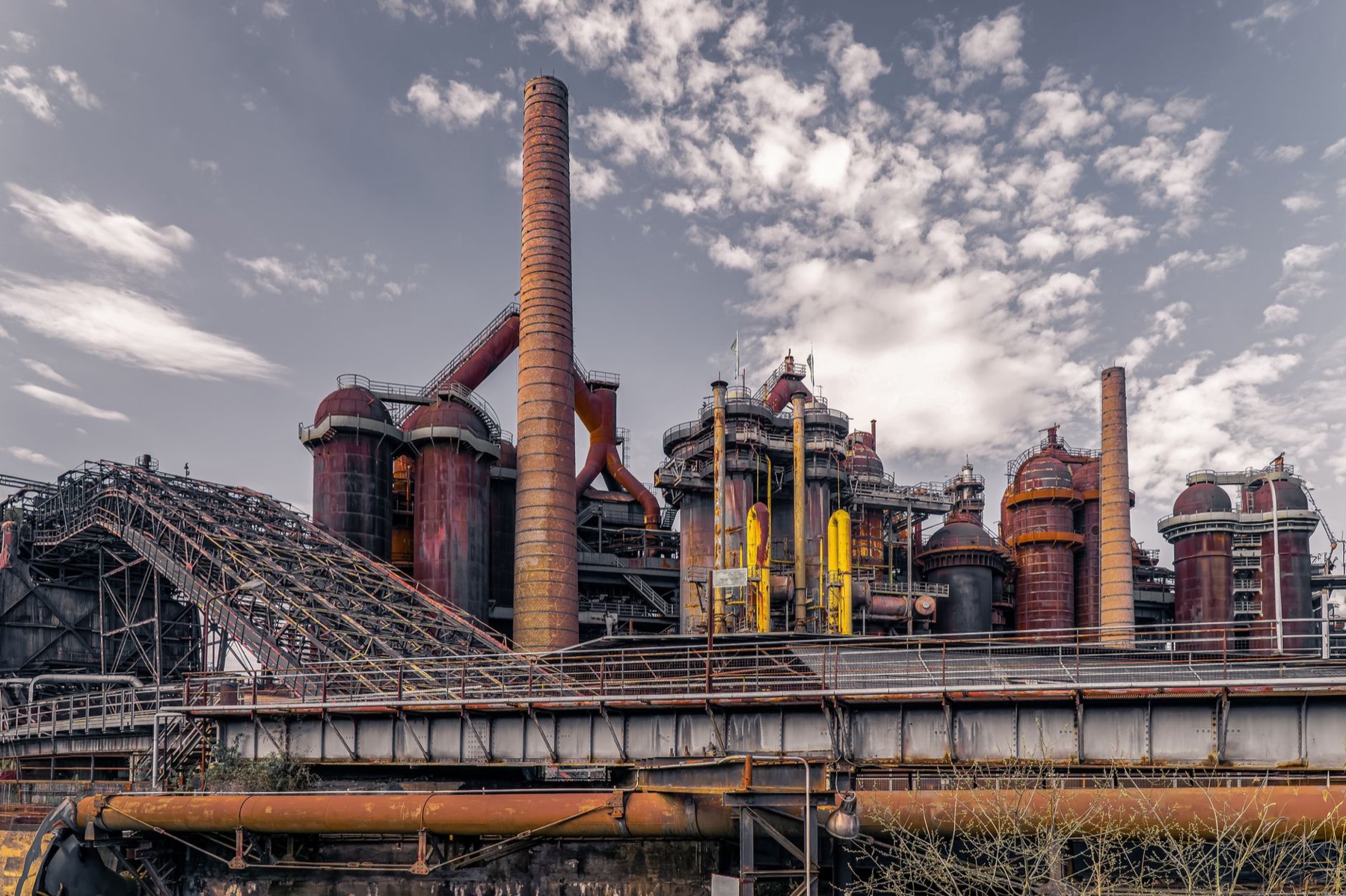 Alto horno industrial contra el cielo, hierro oxidado y chimeneas